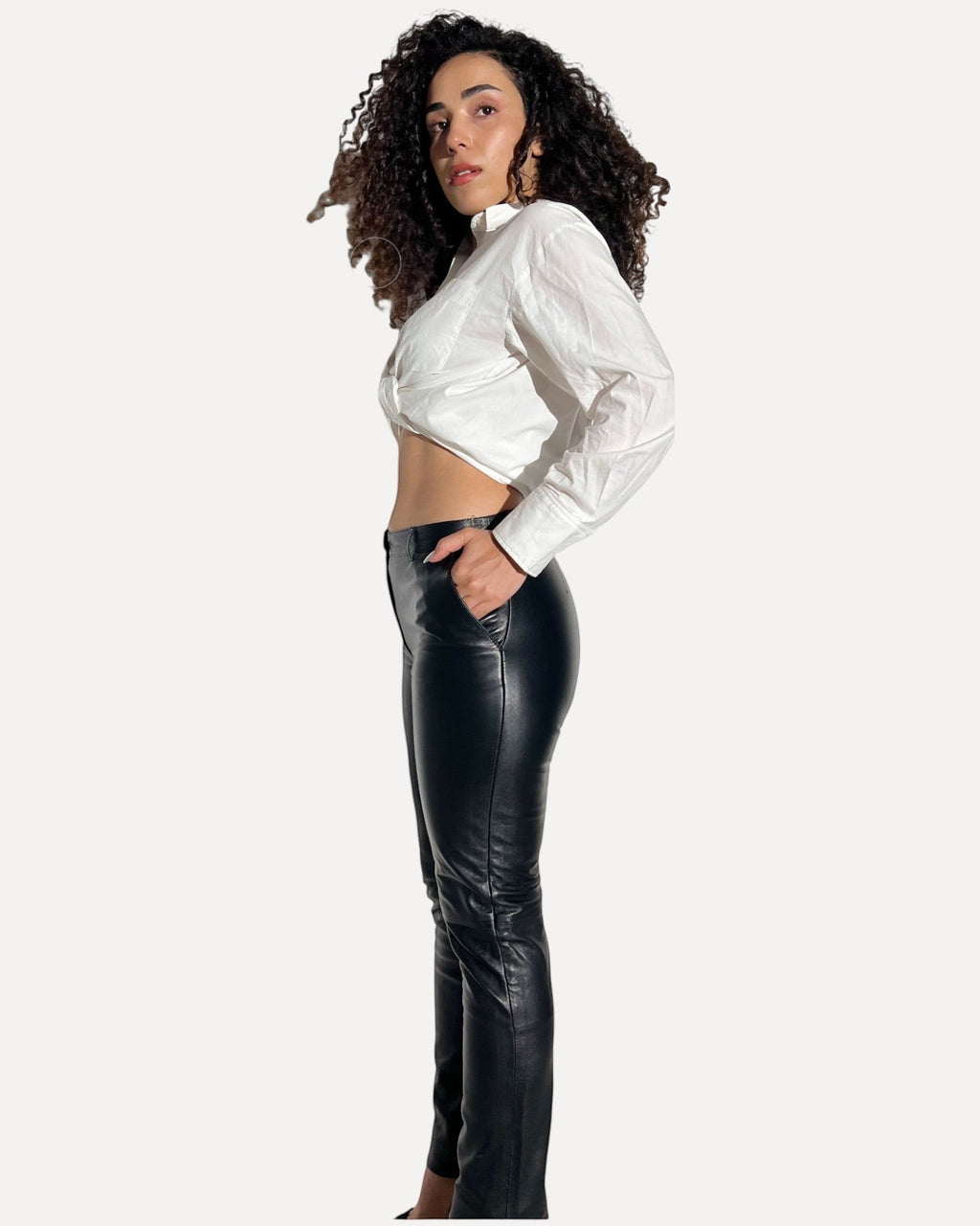 HİLDA DERİ siyah hakiki kuzu derisi cepli slim fit kadın pantolon, beyaz gömlek ile kombinlenmiş yan görünüm.