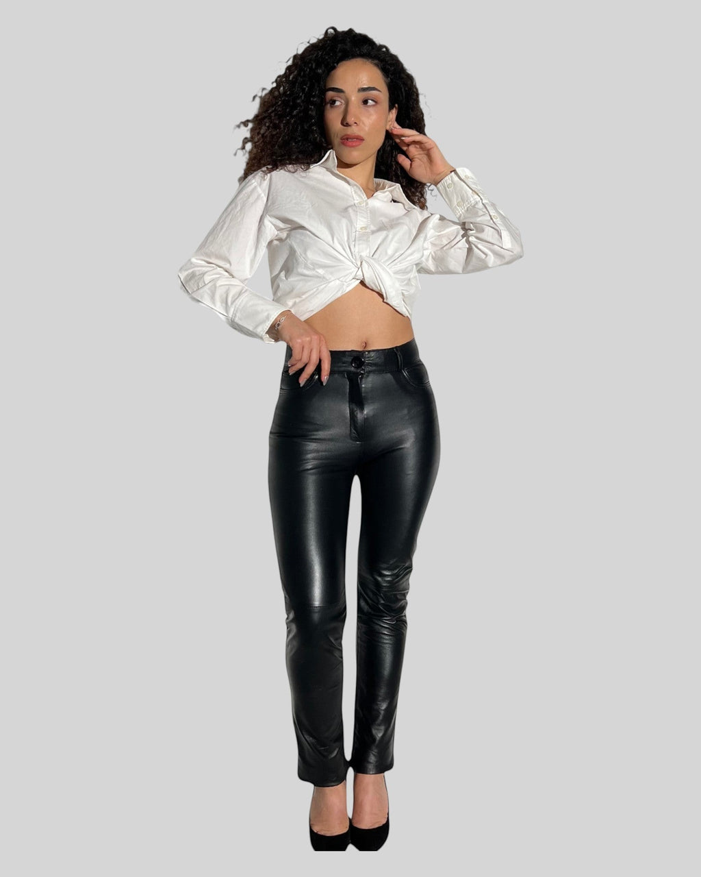 HİLDA DERİ siyah hakiki kuzu derisi jean model 5 cepli kadın pantolon, beyaz gömlek ile kombinlenmiş.