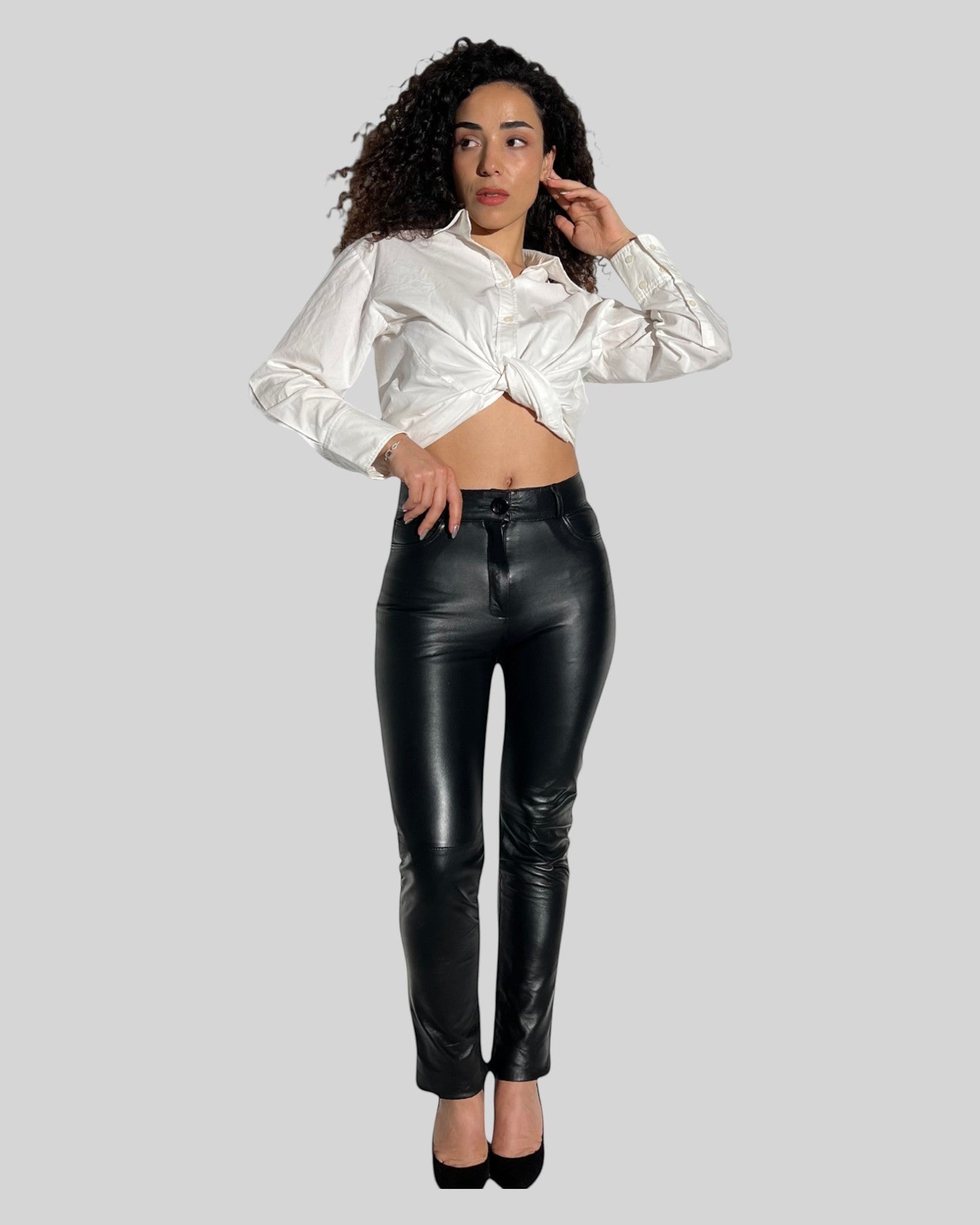 HİLDA DERİ siyah hakiki kuzu derisi jean model 5 cepli kadın pantolon, beyaz gömlek ile kombinlenmiş.